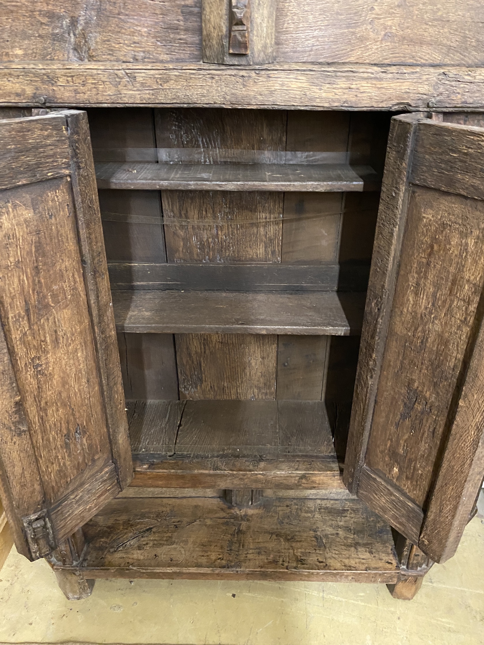 A 17th century style panelled oak side cabinet constructed from old timber, width 157cm, depth 29cm, height 164cm